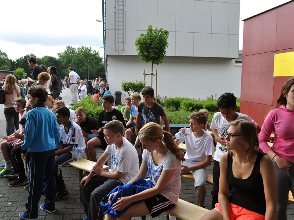 Zuschauer sitzen und stehen am Streckenrand.